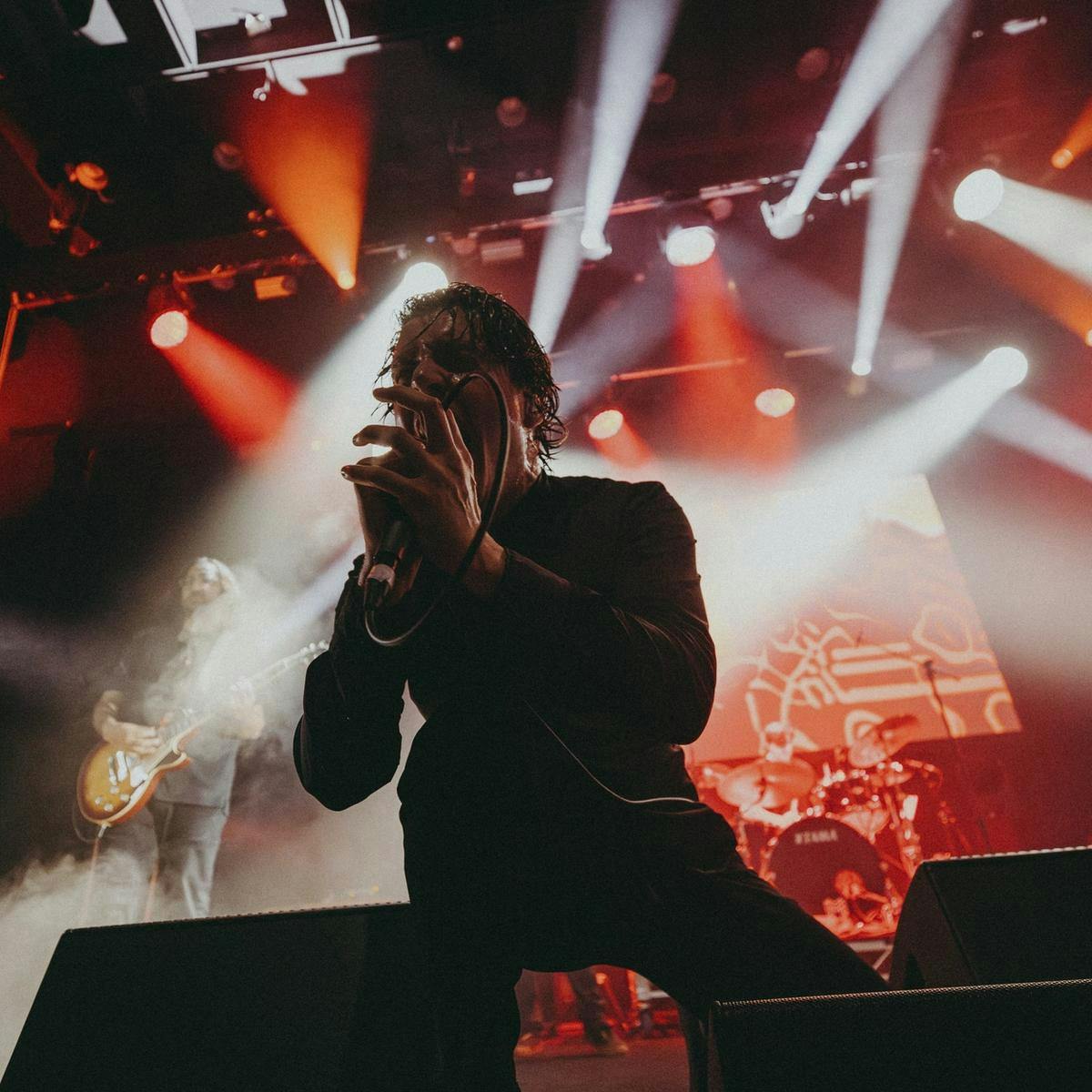 A person on stage screaming in a microphone