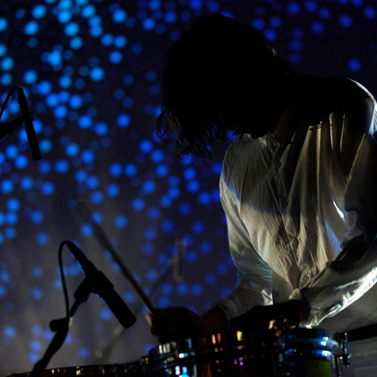 A person playing piano with blue lights in the background.